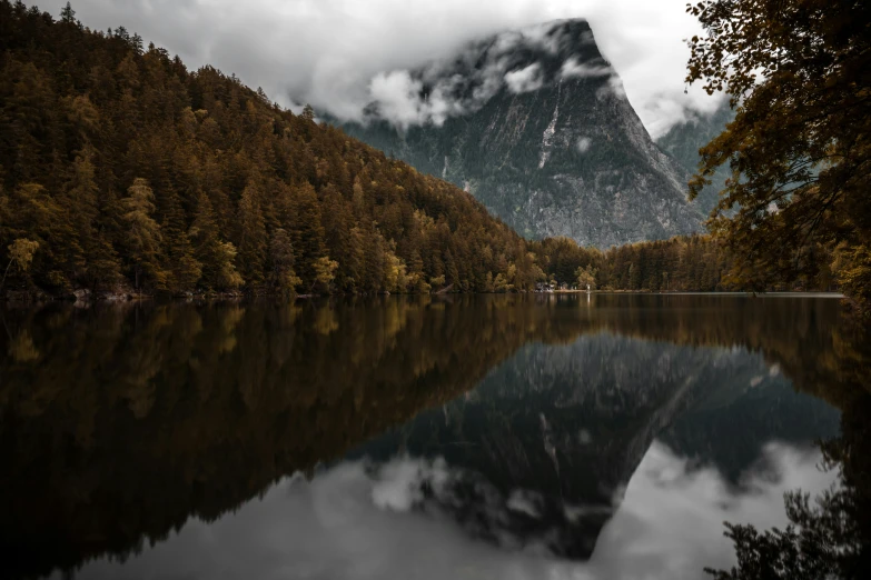 a mountain landscape with a lake and a forest