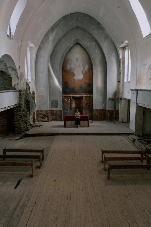 large empty cathedral with wood benches and wall paintings