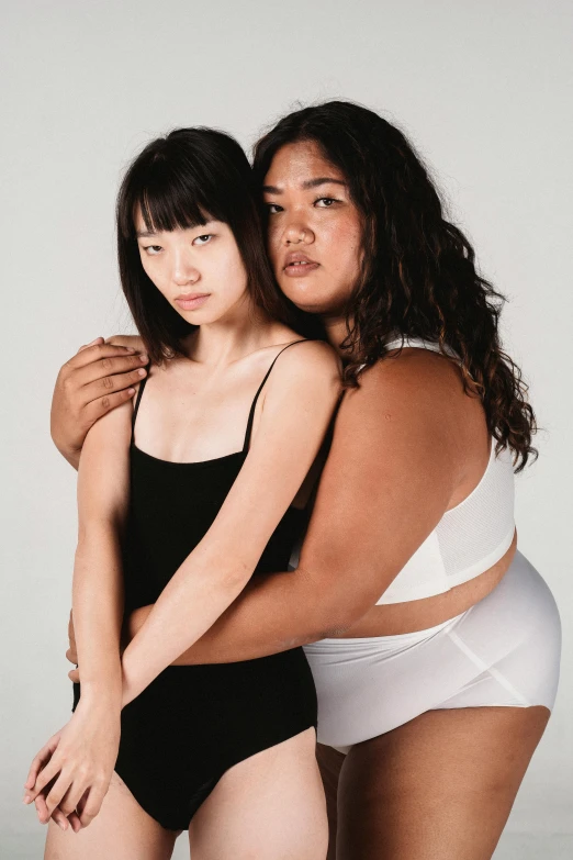 two women hugging each other in underwear