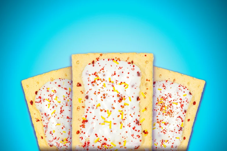 three squares of cake with white icing and sprinkles