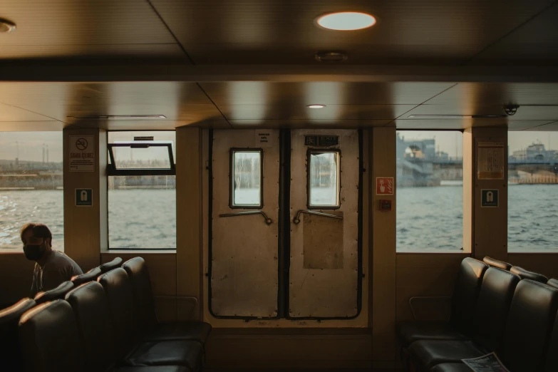 a man sits by the back wall on the boat