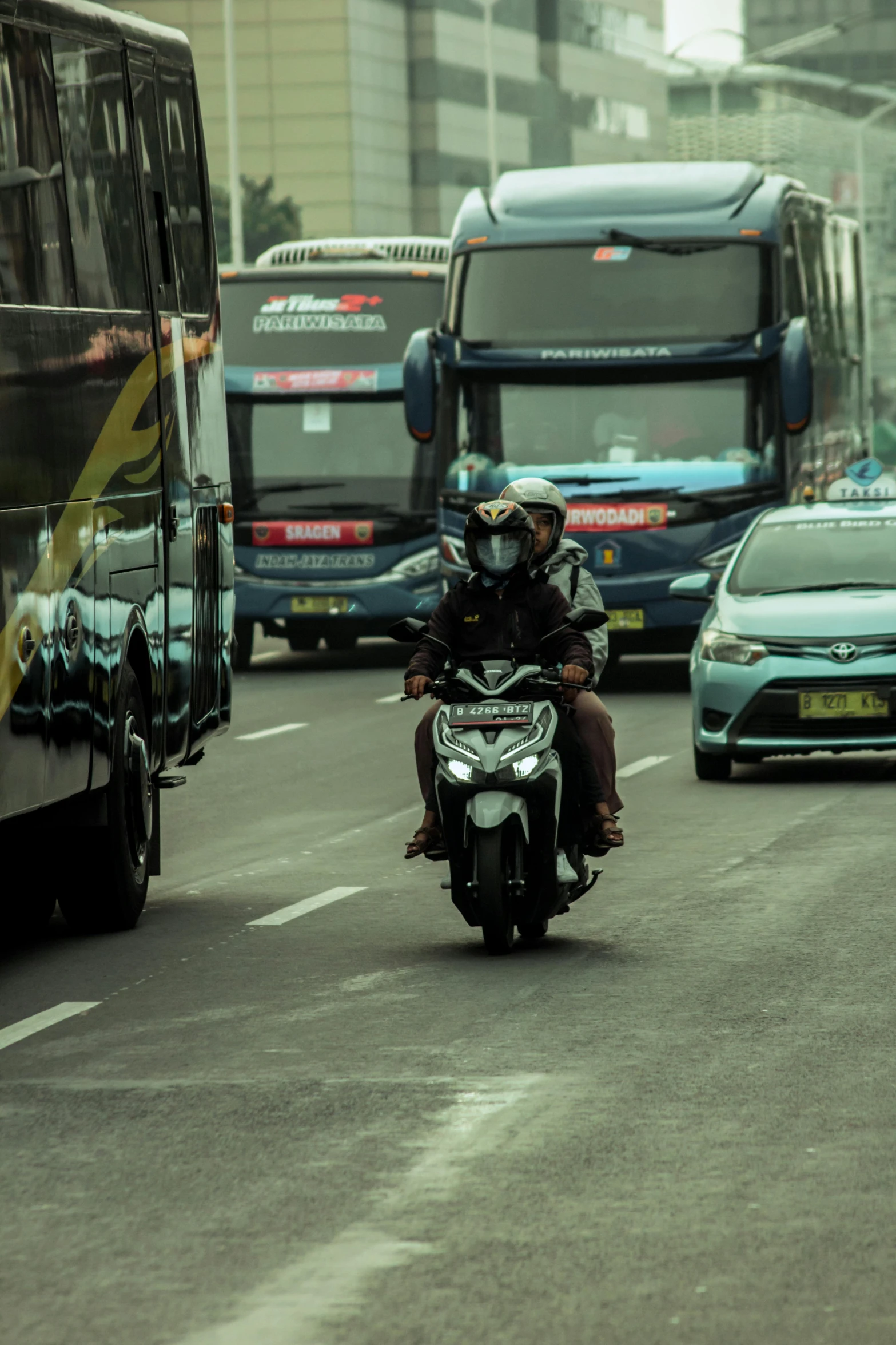 a man is riding a motorcycle next to a bus