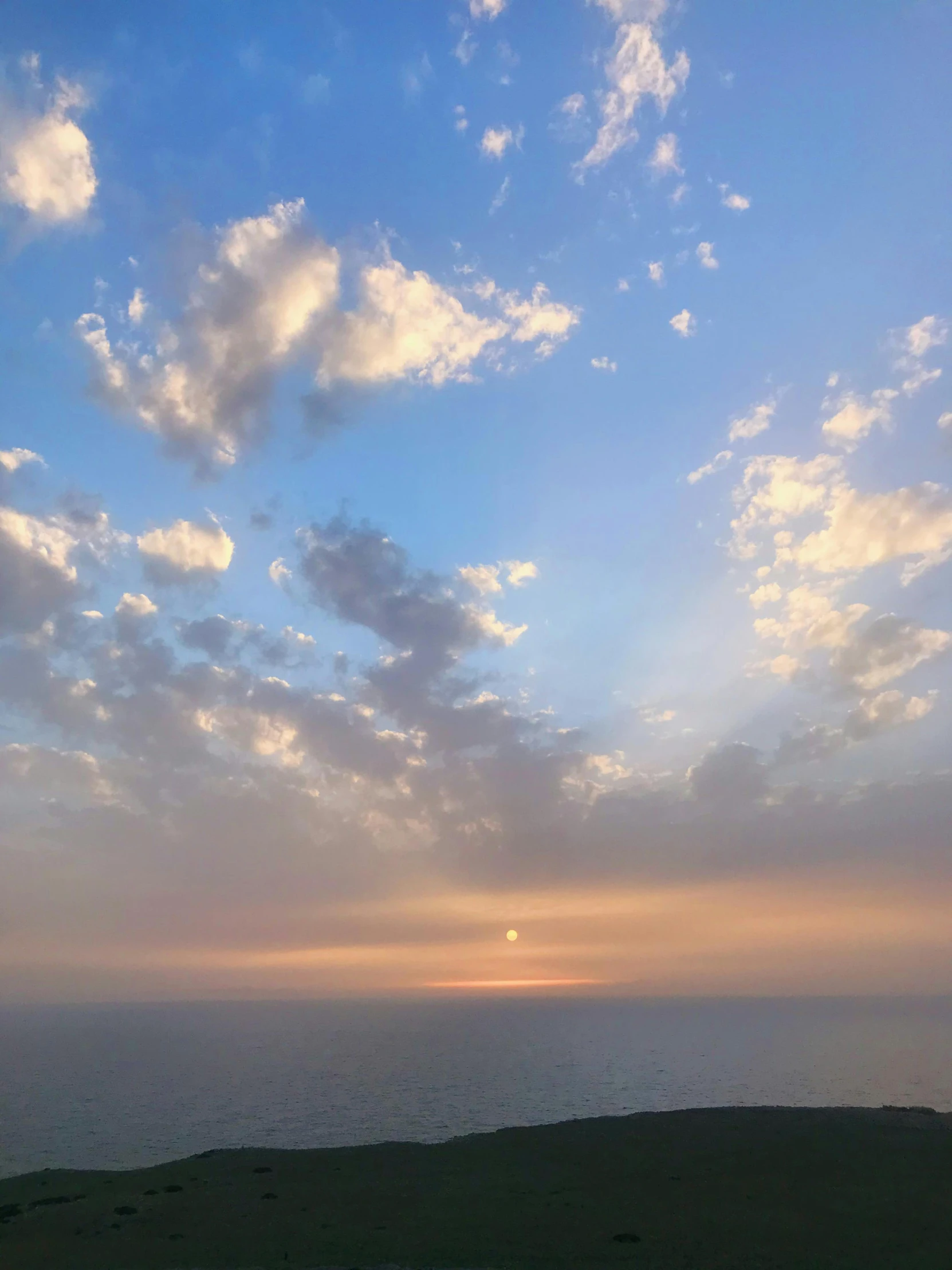 a beach is next to the ocean during sunrise