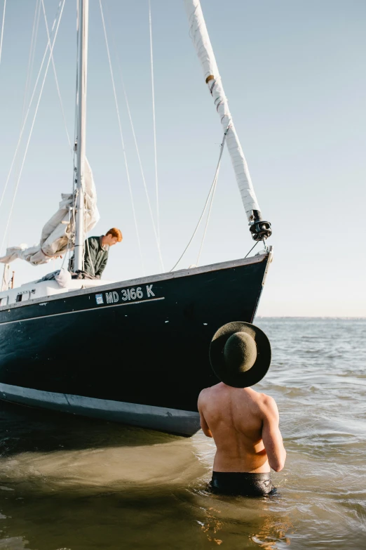 two men that are standing in the water near a boat