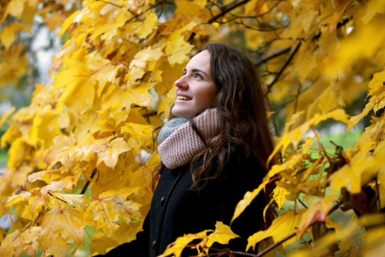 a woman looks up at her hair, but has a scarf around her neck