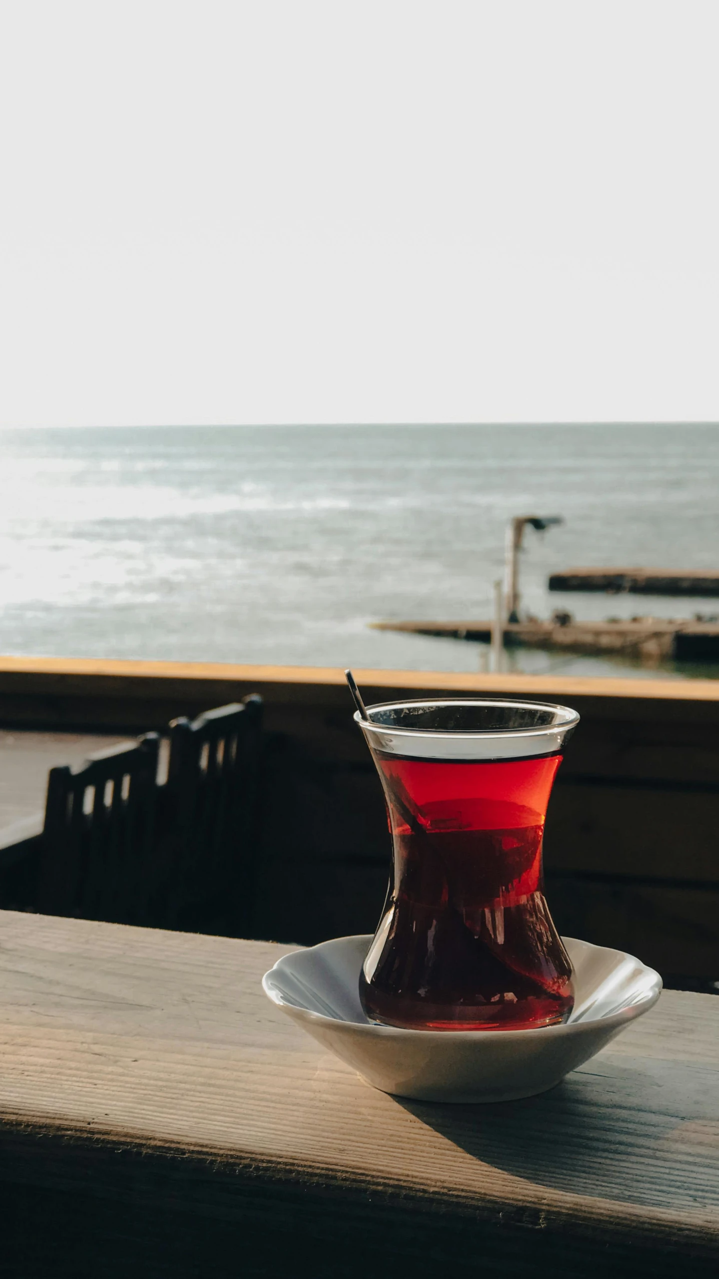 a bowl with liquid sits on top of a table next to the beach