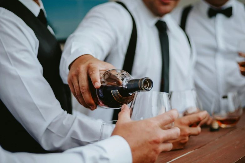 a close up of people with alcohol at a bar