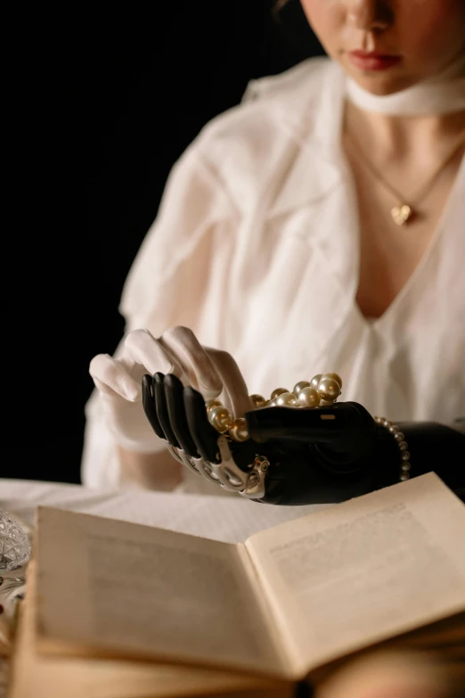 a lady sitting down reading a book on her arm