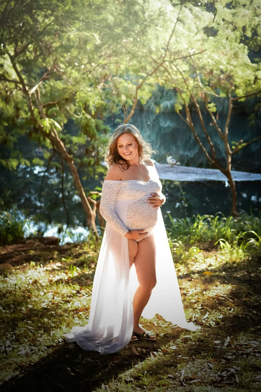 a pregnant woman poses in her gown for her family portrait