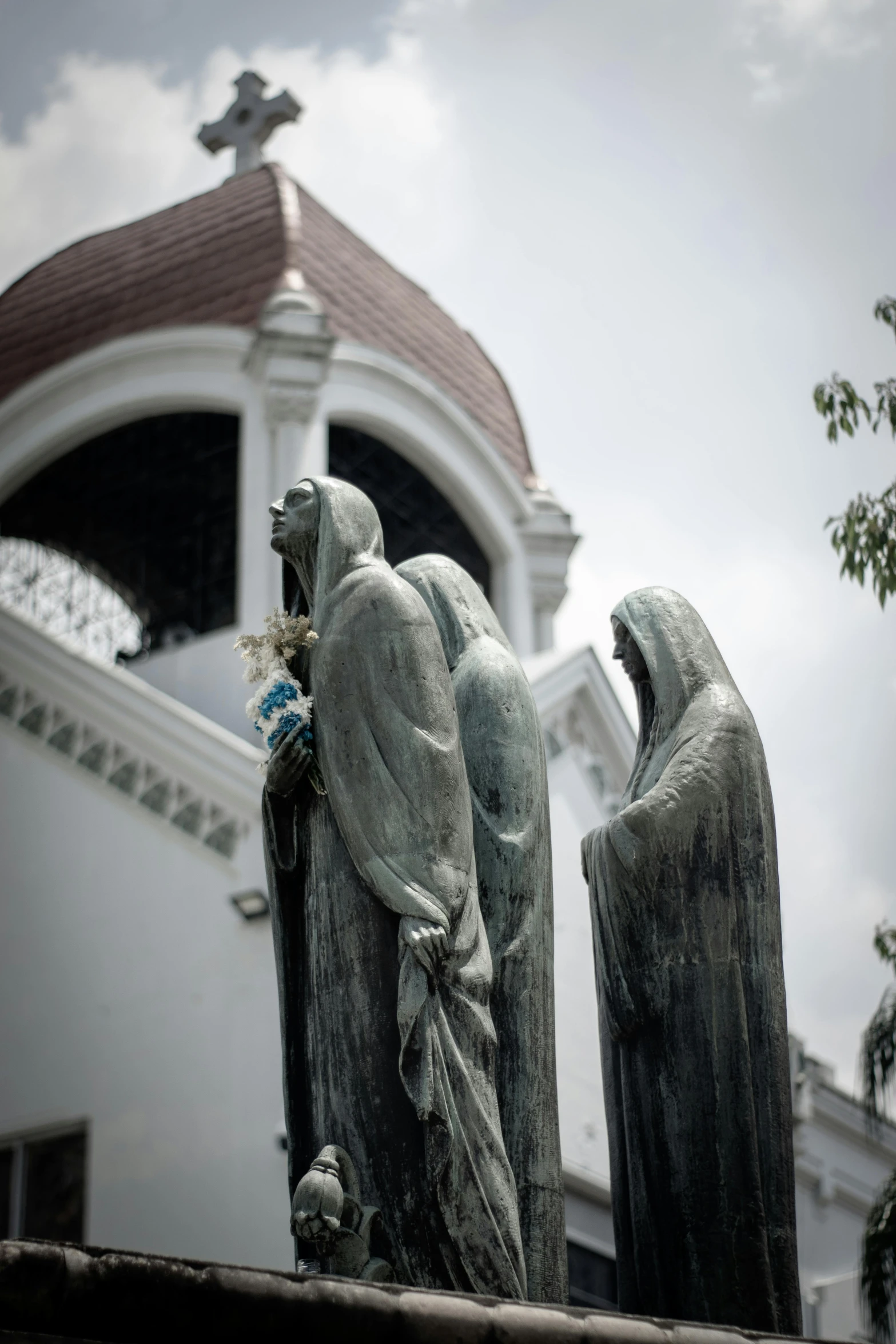 a sculpture on top of a wooden post in front of a church