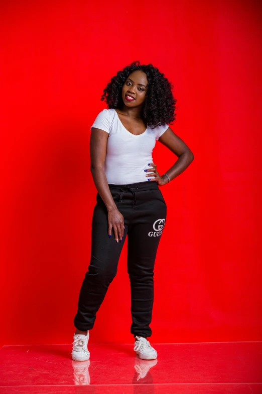 an attractive woman posing for a po in front of a red background