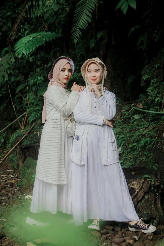 two women dressed in white standing next to each other