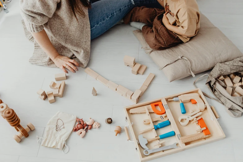 a woman is assembling wooden toys with a little boy