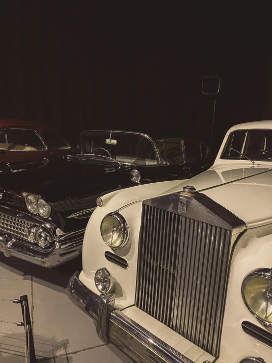 two black and white cars on display in a museum