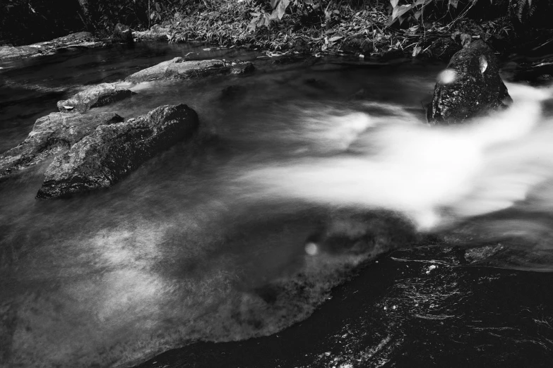 a creek with rapids coming out of the rocks