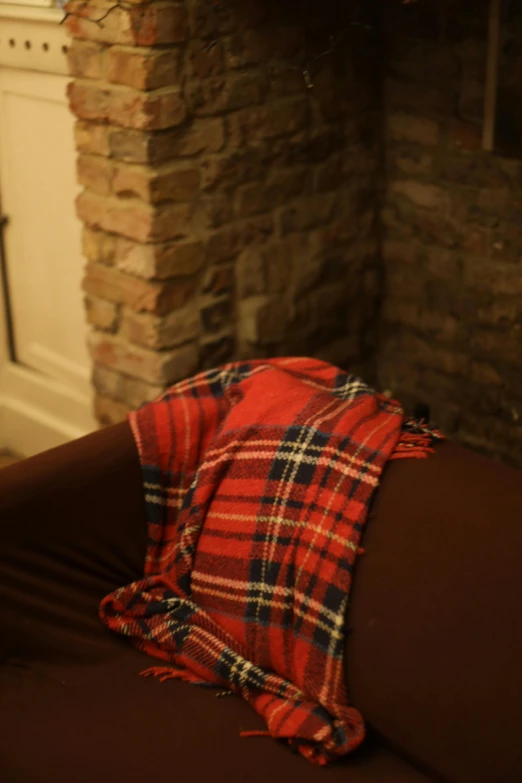 a jacket covered with a tartane sitting on top of a couch