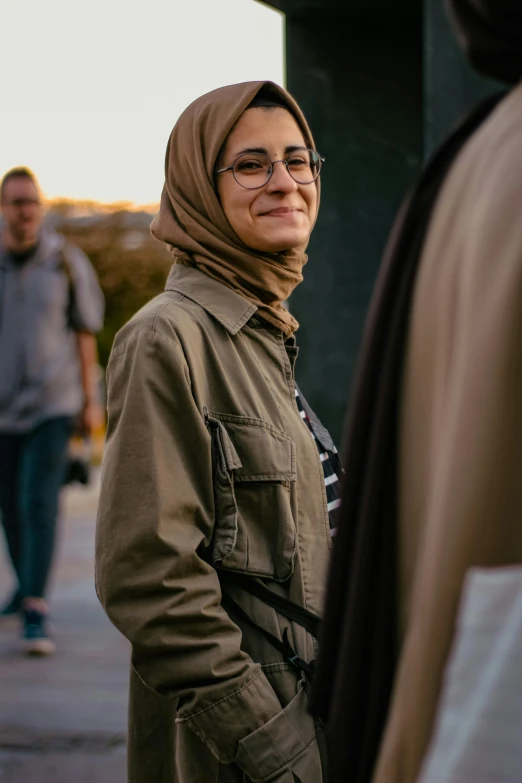 a person wearing a headscarf and a brown jacket