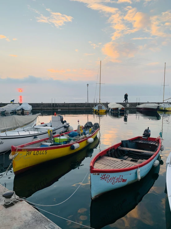 boats are parked at a dock with another boat in the water