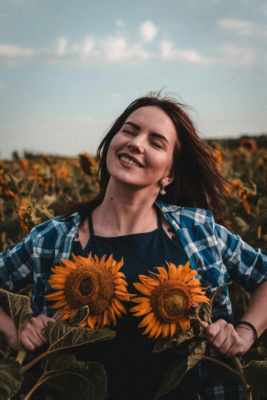 woman smiling in sunflower field with blue sky