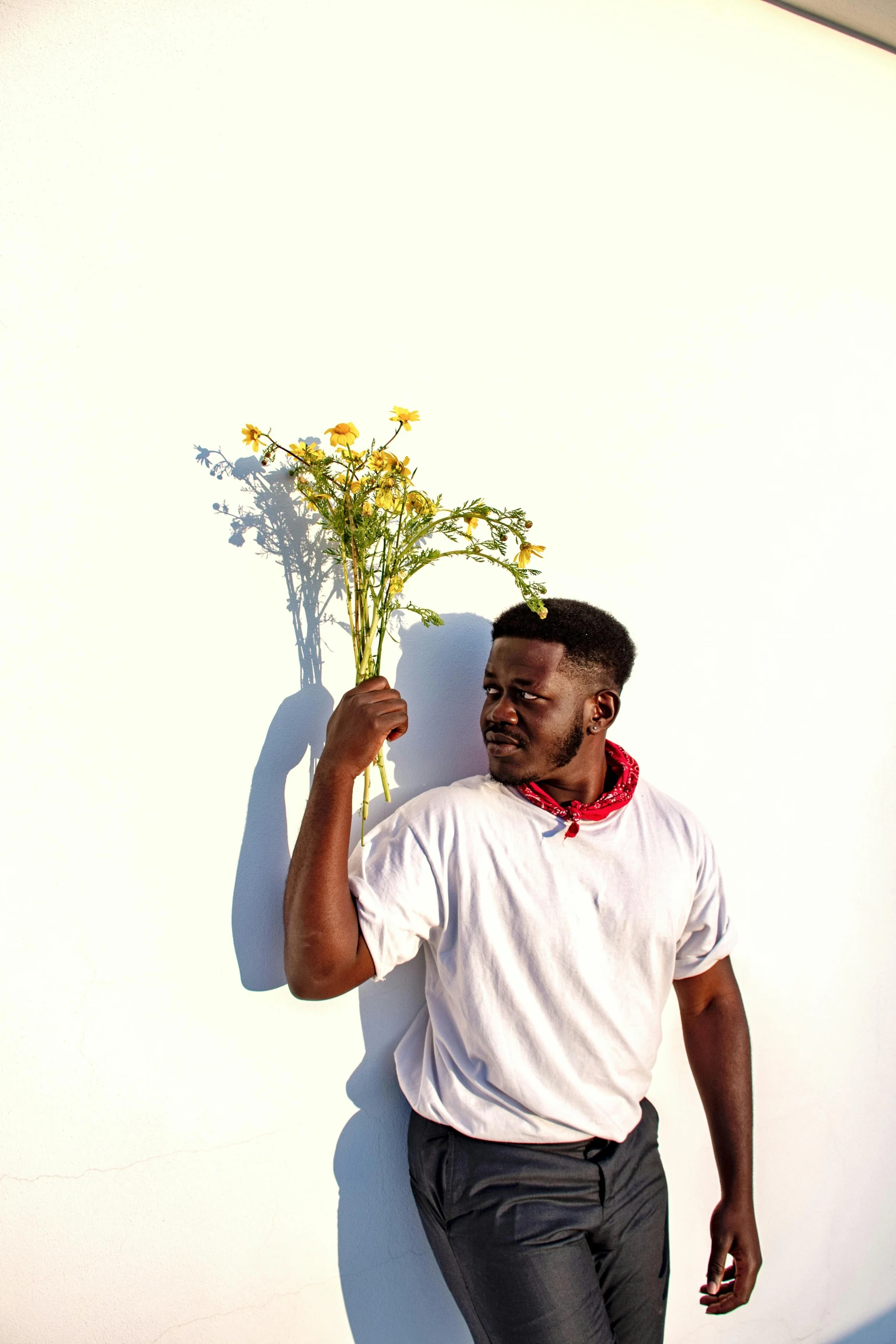 a man in black pants holding a bunch of flowers