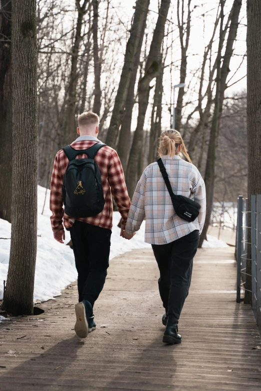 two people walking on the side walk in the winter