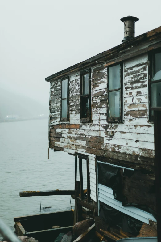 an old run down wooden boat house near water