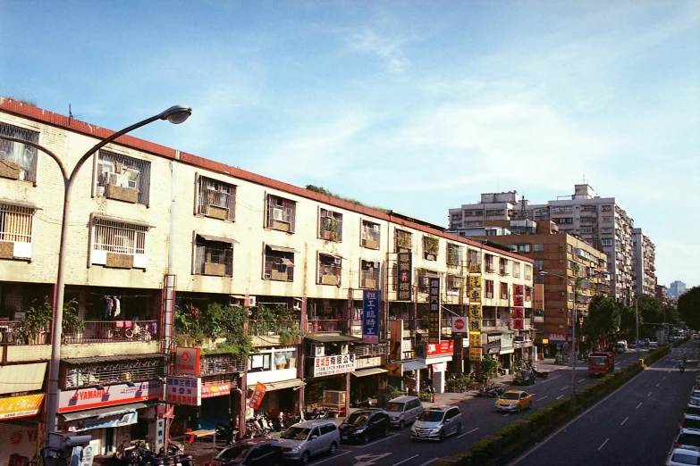 a street with cars driving by buildings with a lot of windows