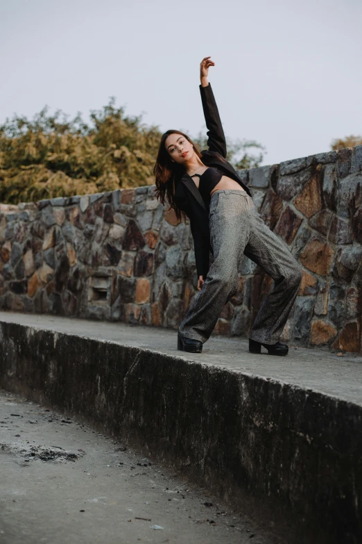 a woman standing on a ledge and posing for a picture