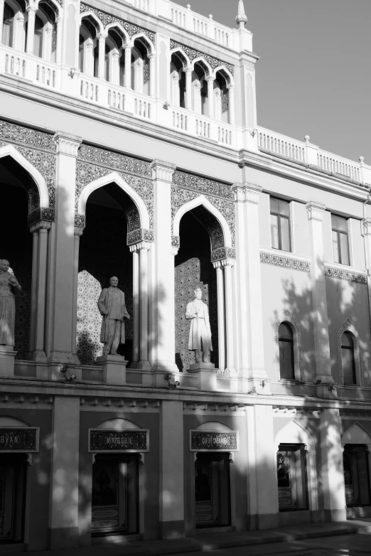 statues sit on the columns of a building