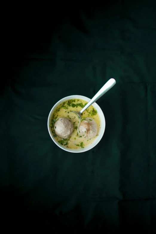 a bowl of soup with two clumps and broth in it