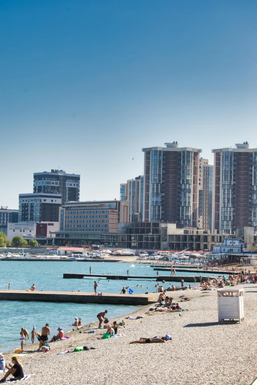 people relaxing on a beach next to a body of water