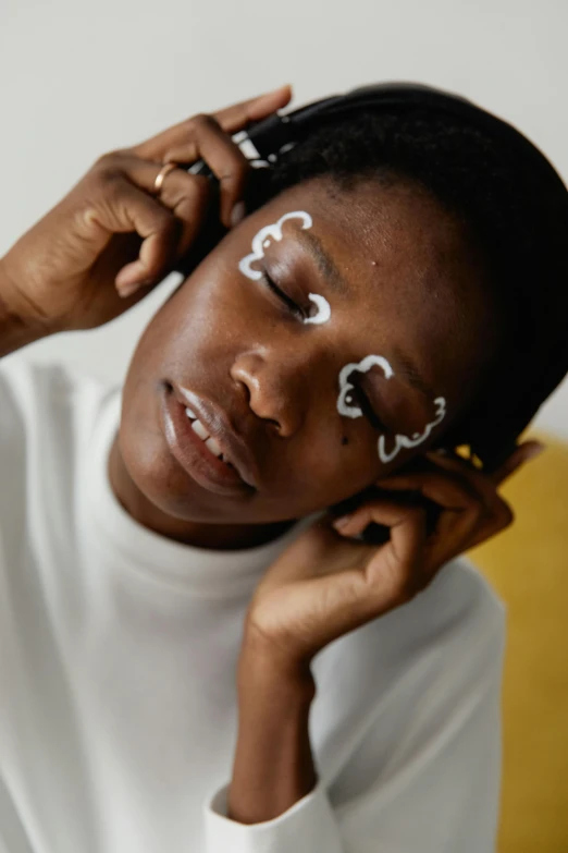 a woman with eye makeup on holding a hair piece