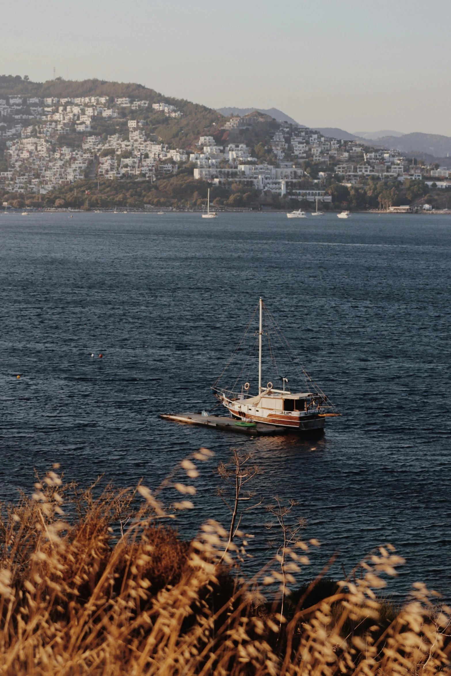 an empty boat floating on the ocean by a town