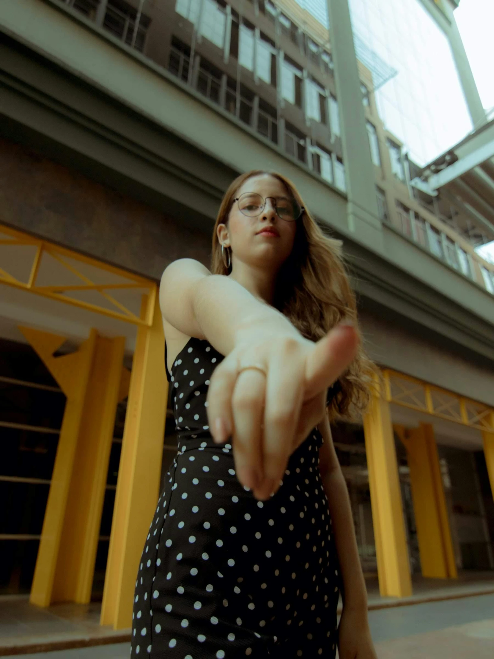 a woman in a polka dot dress pointing at the camera