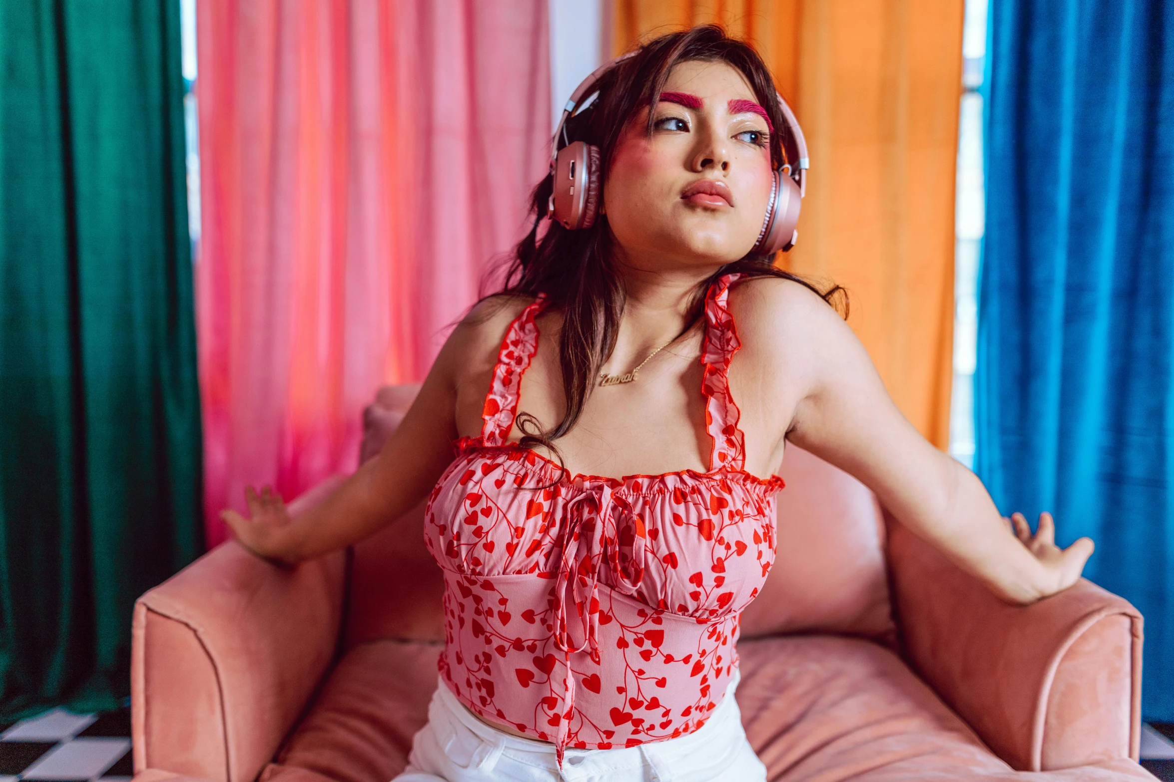 a woman sitting on top of a pink couch