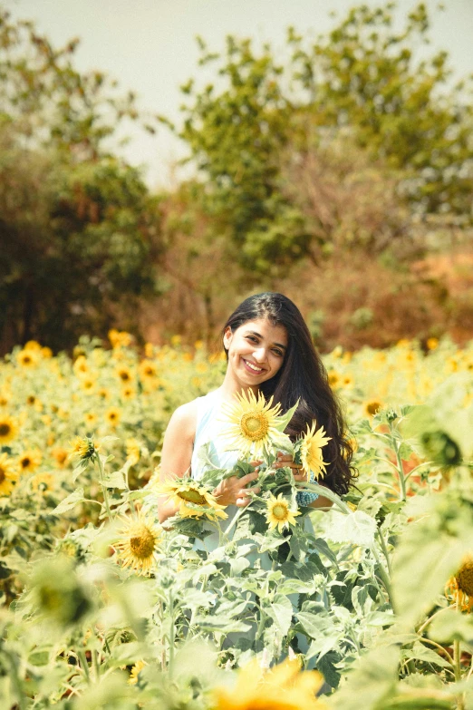 a woman in a sunflower field posing for the camera