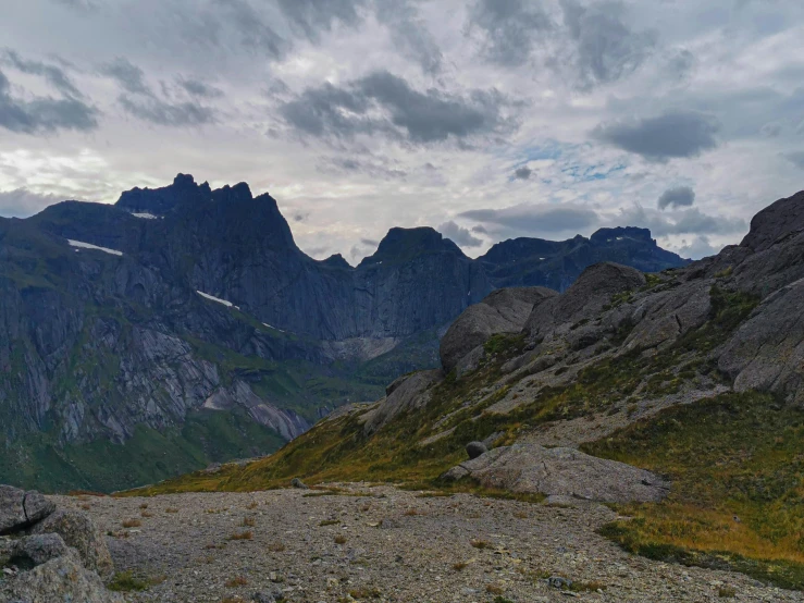 a valley has some very large mountains in the background