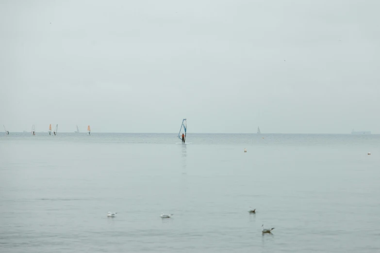 a man standing in the water looking out over the water