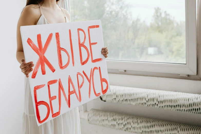 woman holding sign saying xybibeeancy on it