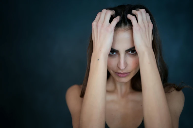 the woman is posing with hands on her head