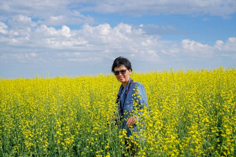 man in sunglasses standing in the middle of tall field