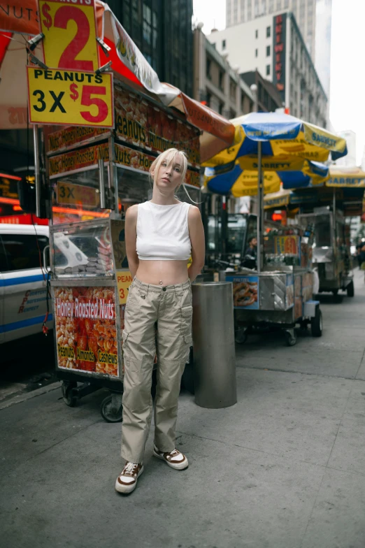 a woman is standing by food stands in the street