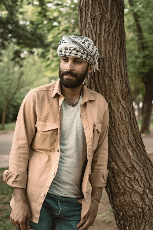 a man stands next to a tree in a park