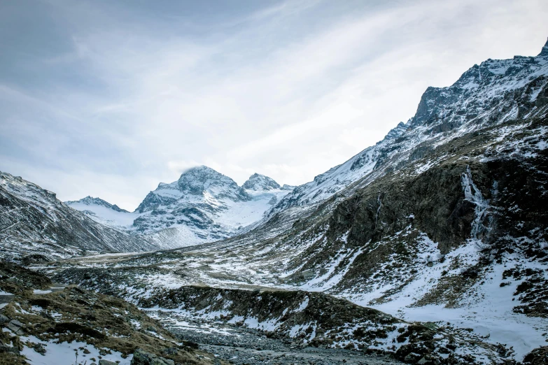 a mountain range filled with snow and low lying clouds