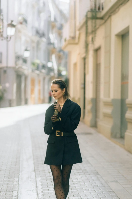 a woman walks on the street and holds her purse