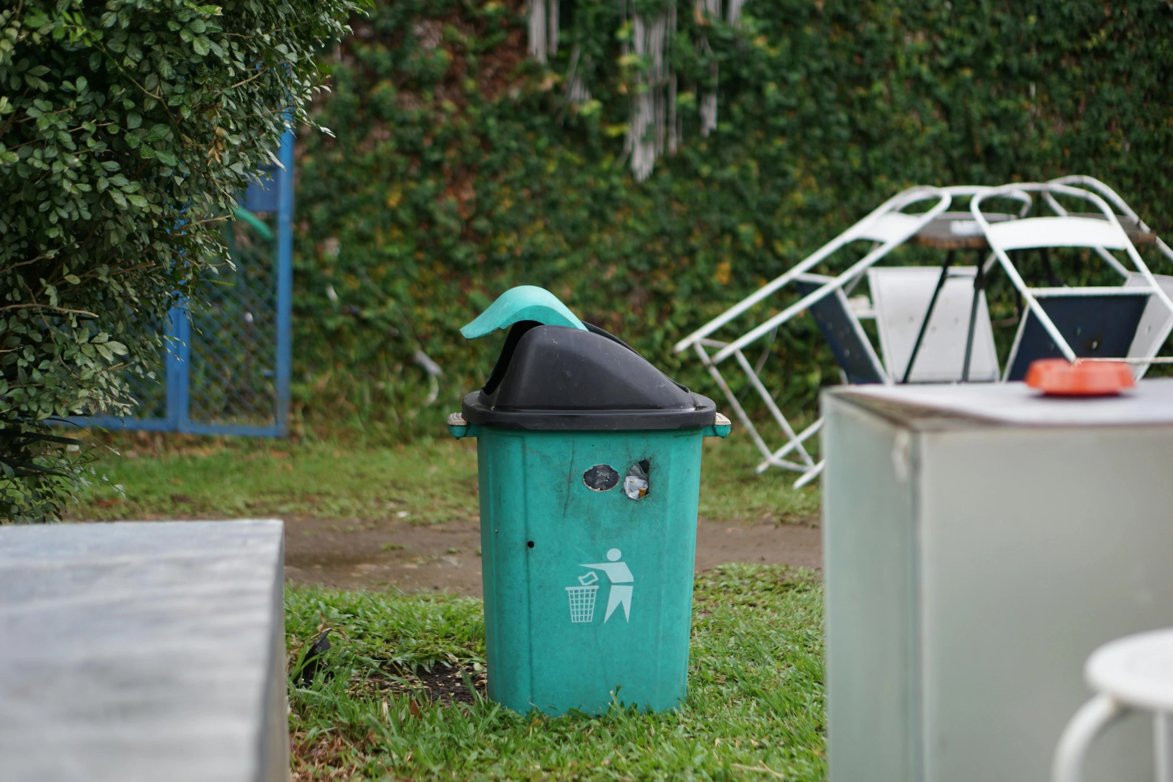 two green trash cans with eyes drawn on them