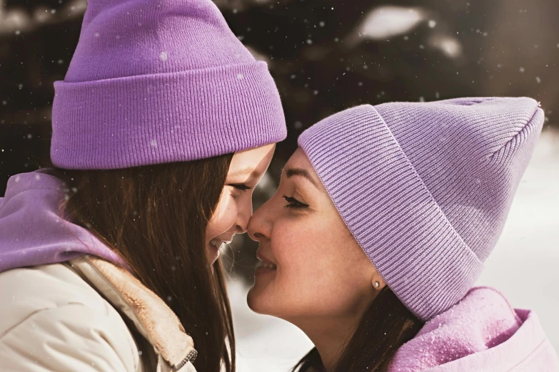 two s smiling and kissing in the snow