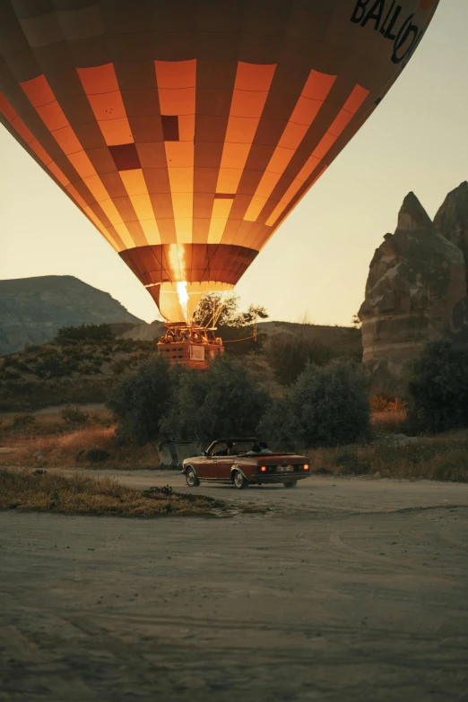 the  air balloon rises over two antique cars