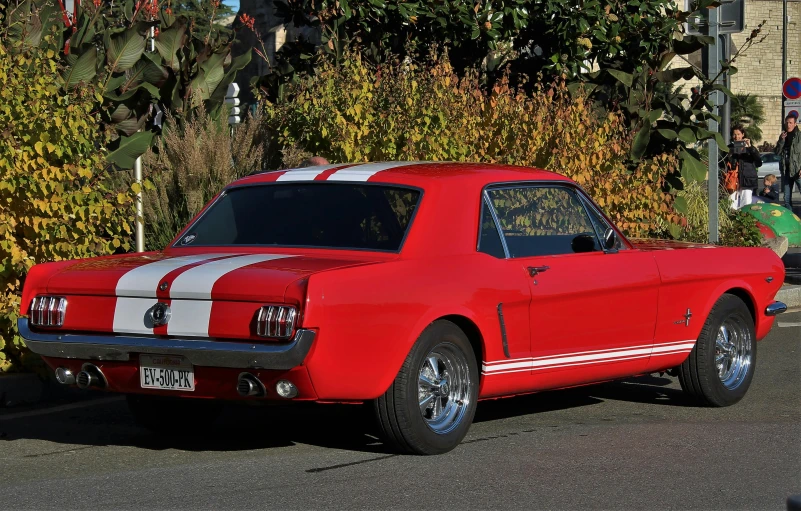 an old red car with a white stripe on it