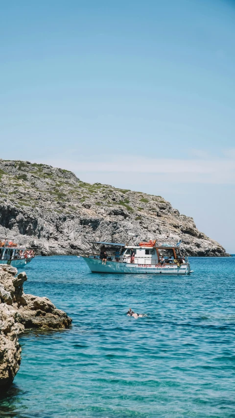 a boat with passengers floats on the blue sea